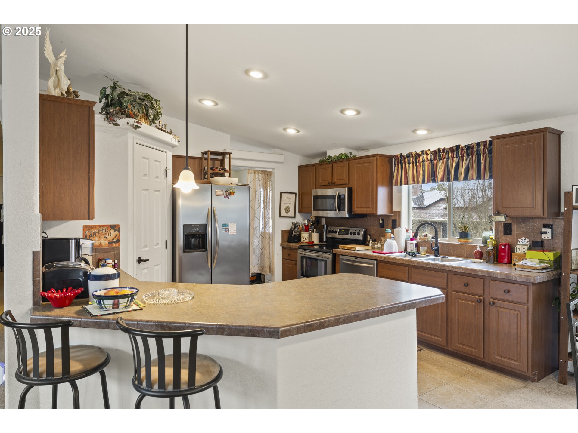 4015 Southwest 185th Avenue Beaverton, OR 97078 - Photo 28 of 47 a kitchen with stainless steel appliances kitchen island granite countertop a refrigerator a stove a sink dishwasher and white cabinets with wooden floor
