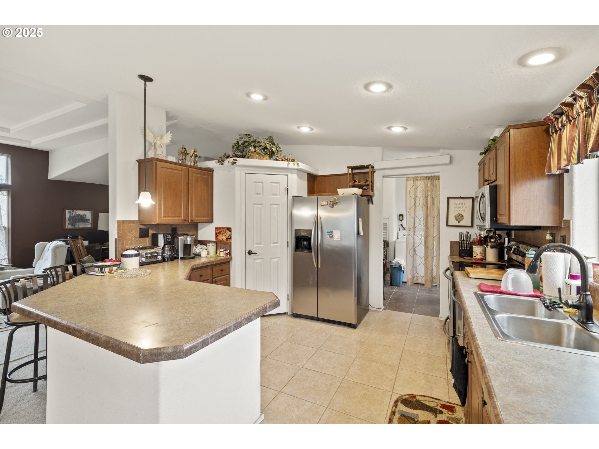 4015 Southwest 185th Avenue Beaverton, OR 97078 - Photo 31 of 47 a kitchen with kitchen island a refrigerator and a sink