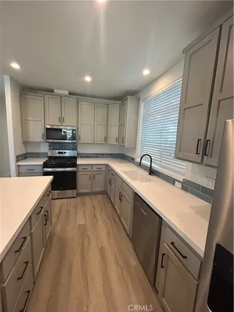 a kitchen with kitchen island granite countertop a sink stainless steel appliances and cabinets