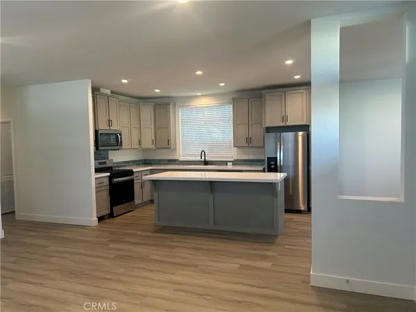 a kitchen with stainless steel appliances granite countertop a refrigerator and a stove top oven
