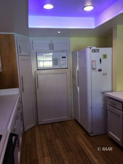 224 West Rader Avenue Ridgecrest, CA 93555 - Photo 10 of 26 a kitchen with a refrigerator and wooden floor