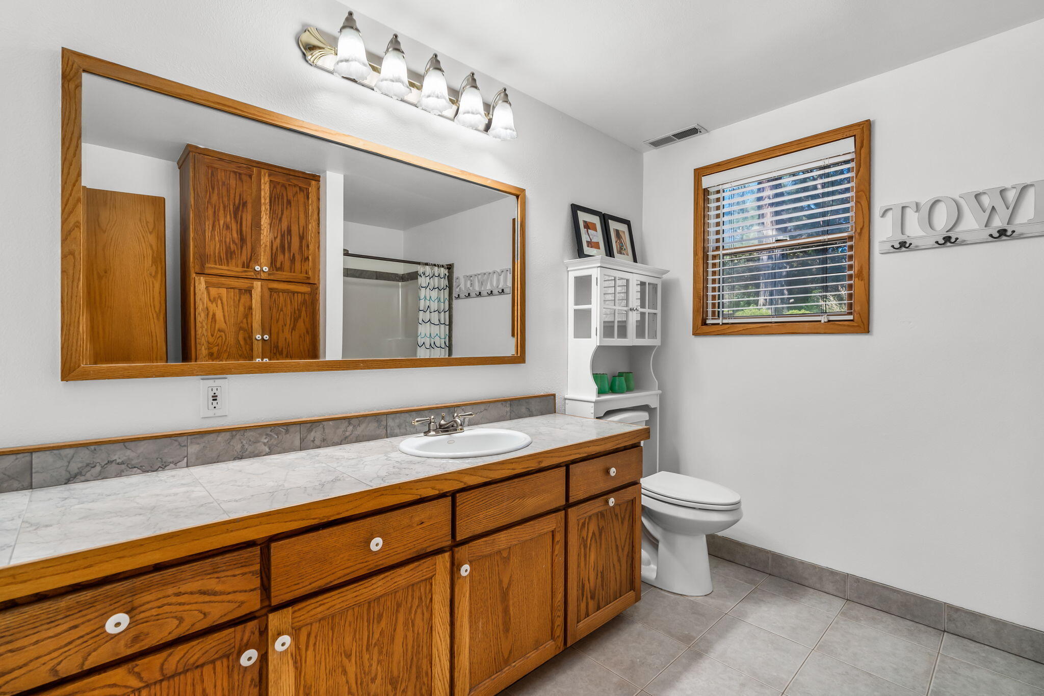 65161 Smokey Butte Road Bend, OR 97703 - Photo 18 of 45 a bathroom with a sink a mirror and a toilet