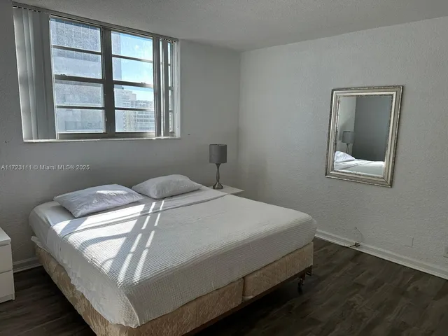 a large bed sitting in a bedroom next to a window with a table