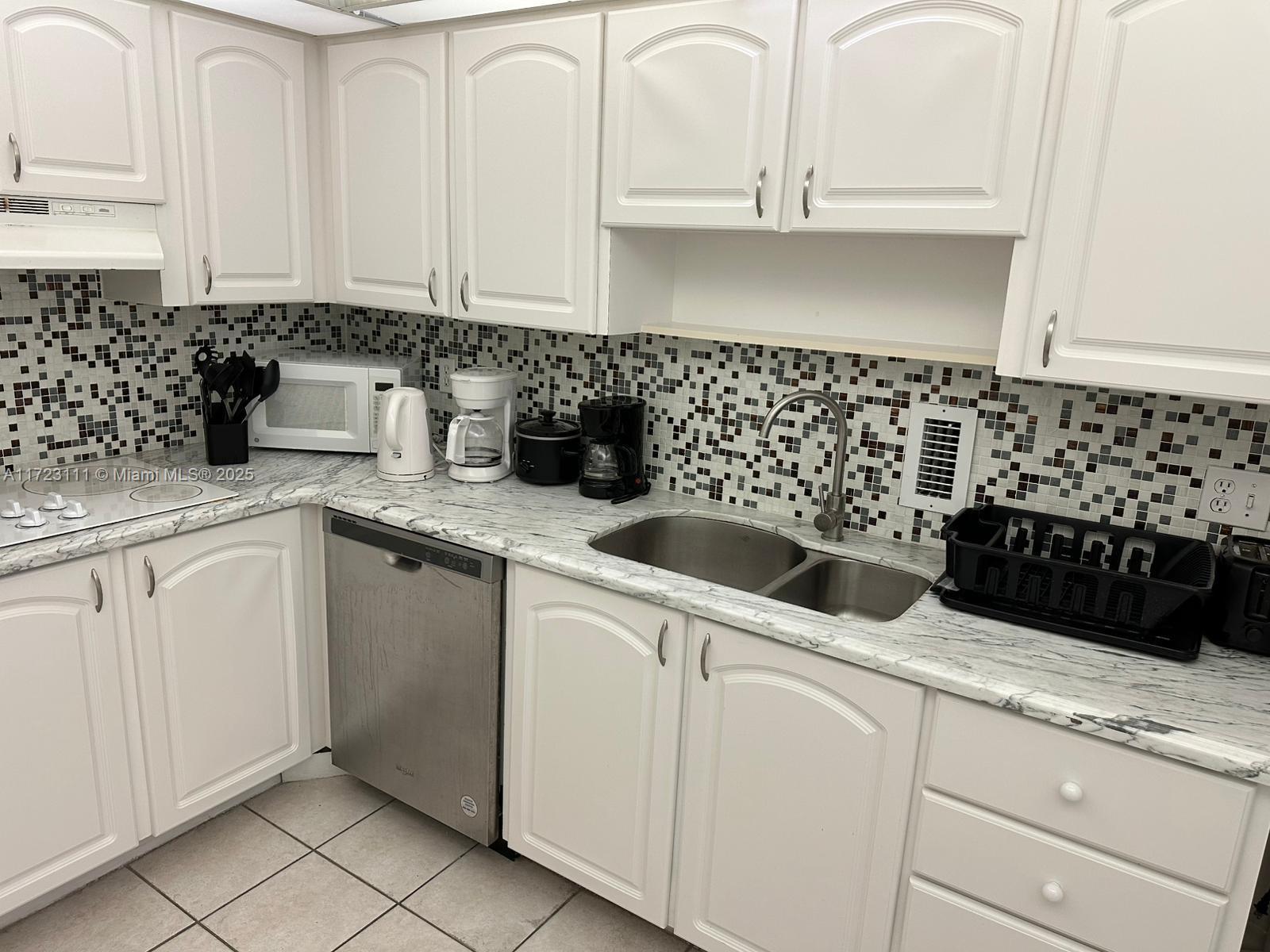 4001 South Ocean Drive, Unit 10D Hollywood, FL 33019 - Photo 13 of 28 a kitchen with granite countertop white cabinets and white appliances