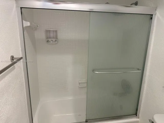 a white toilet sitting next to a bathroom sink and tub