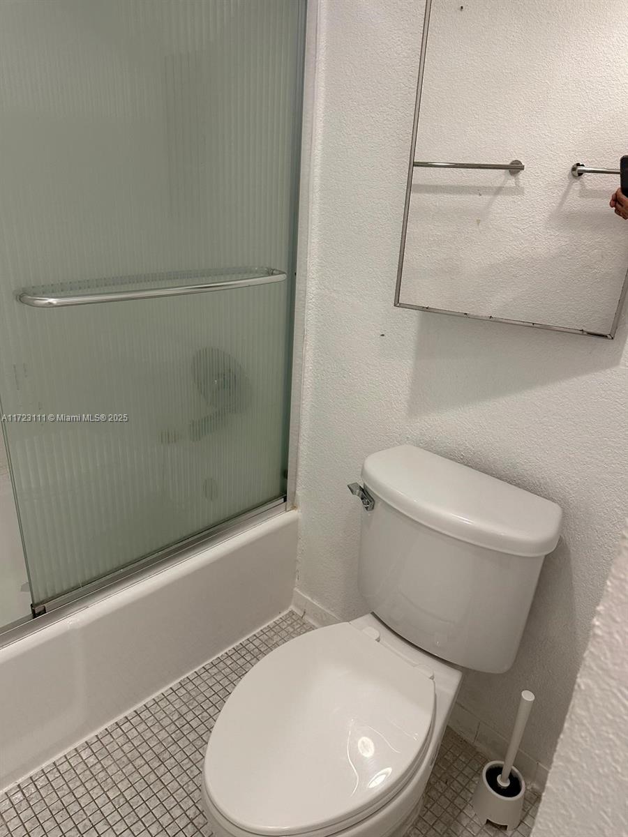 4001 South Ocean Drive, Unit 10D Hollywood, FL 33019 - Photo 16 of 28 a white toilet sitting next to a bathroom sink and tub