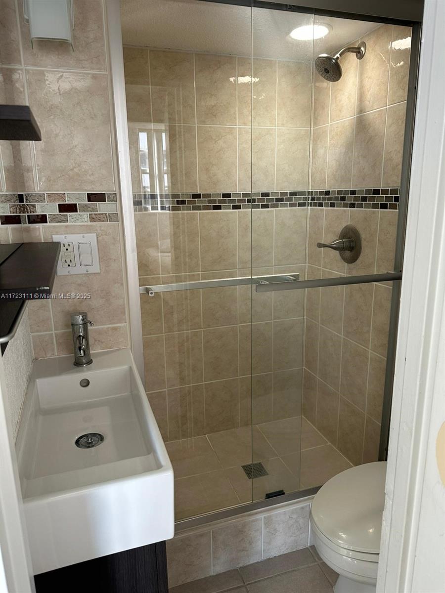 4001 South Ocean Drive, Unit 10D Hollywood, FL 33019 - Photo 18 of 28 a bathroom with a shower sink and mirror