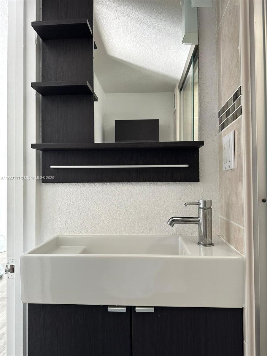 4001 South Ocean Drive, Unit 10D Hollywood, FL 33019 - Photo 20 of 28 a bathroom with a sink and a mirror