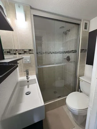 a bathroom with a sink toilet and shower