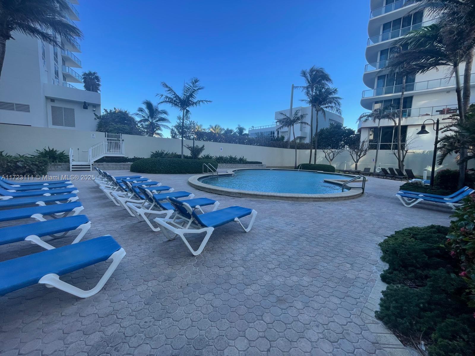 4001 South Ocean Drive, Unit 10D Hollywood, FL 33019 - Photo 23 of 28 a swimming pool with outdoor seating and yard