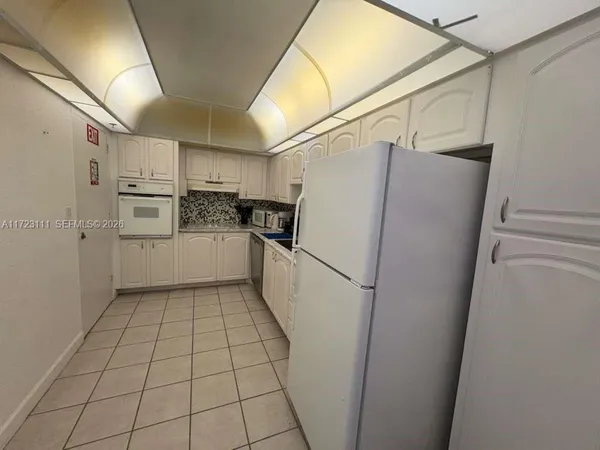a kitchen with white cabinets and white appliances