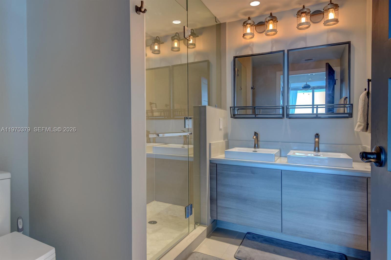 1080 Brickell Avenue, Unit 4101 Miami, FL 33131 - Photo 4 of 11 a bathroom with a granite countertop sink mirror and toilet