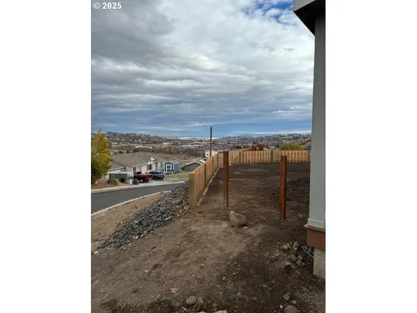a view of a house with a small yard and wooden fence