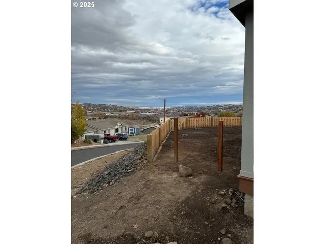 a view of a house with a small yard and wooden fence
