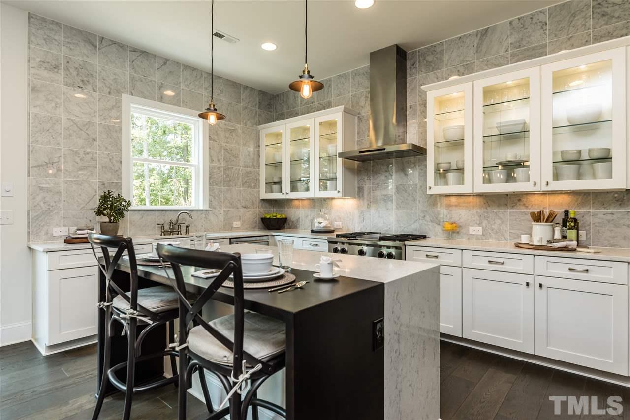 5285 Aleppo Lane Raleigh, NC 27613 - Photo 7 of 25 a kitchen with a table chairs stove and cabinets