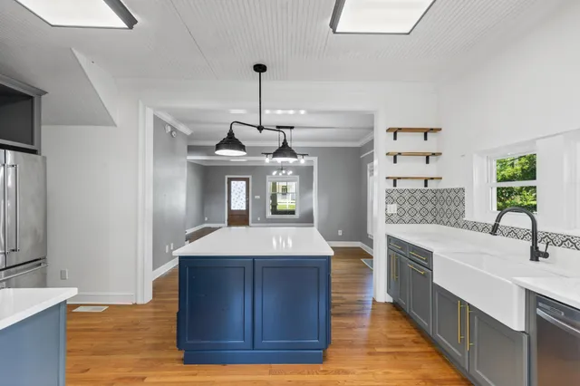 a kitchen with granite countertop a refrigerator and a stove top oven