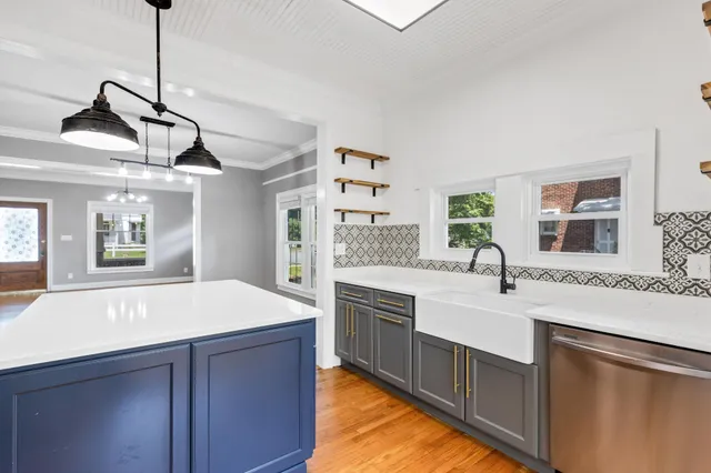 a large kitchen with kitchen island a stove a sink a refrigerator and a dining table