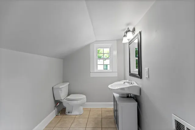 a view of hallway with wooden floor and windows
