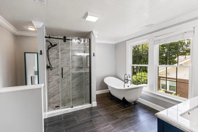 a bathroom with a double vanity sink a mirror and a bathtub