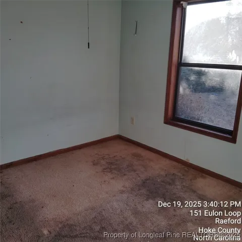 a view of a small space with wooden floor and a window
