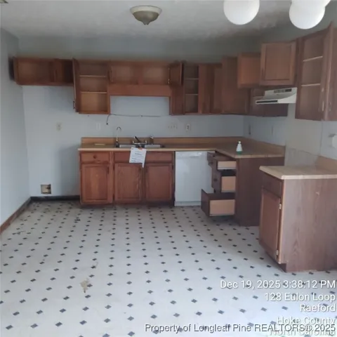 a kitchen with a sink a stove and cabinets