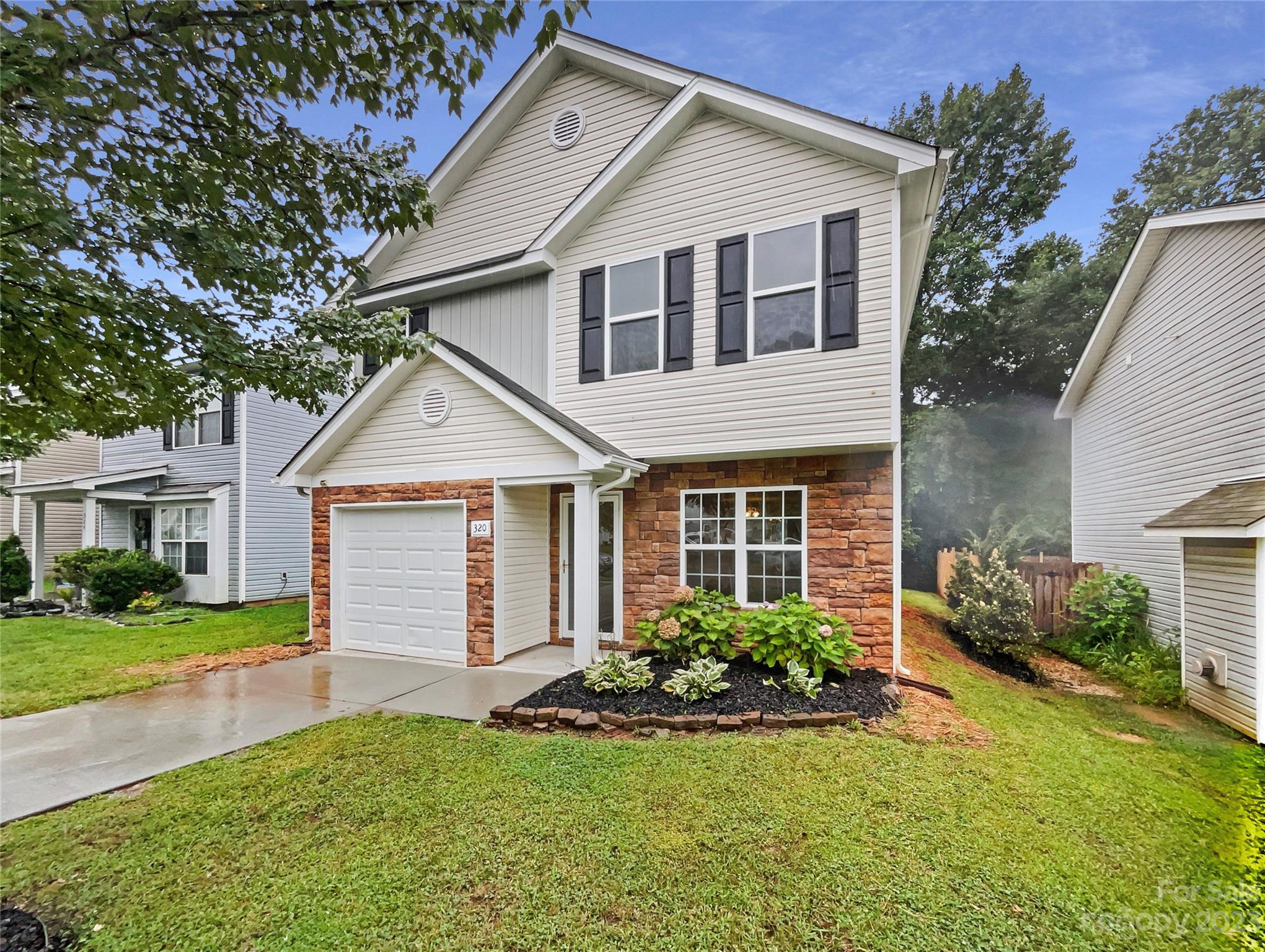 320 Peachtree Road Charlotte, NC 28216 - Photo 1 of 18 a front view of a house with a yard and garage