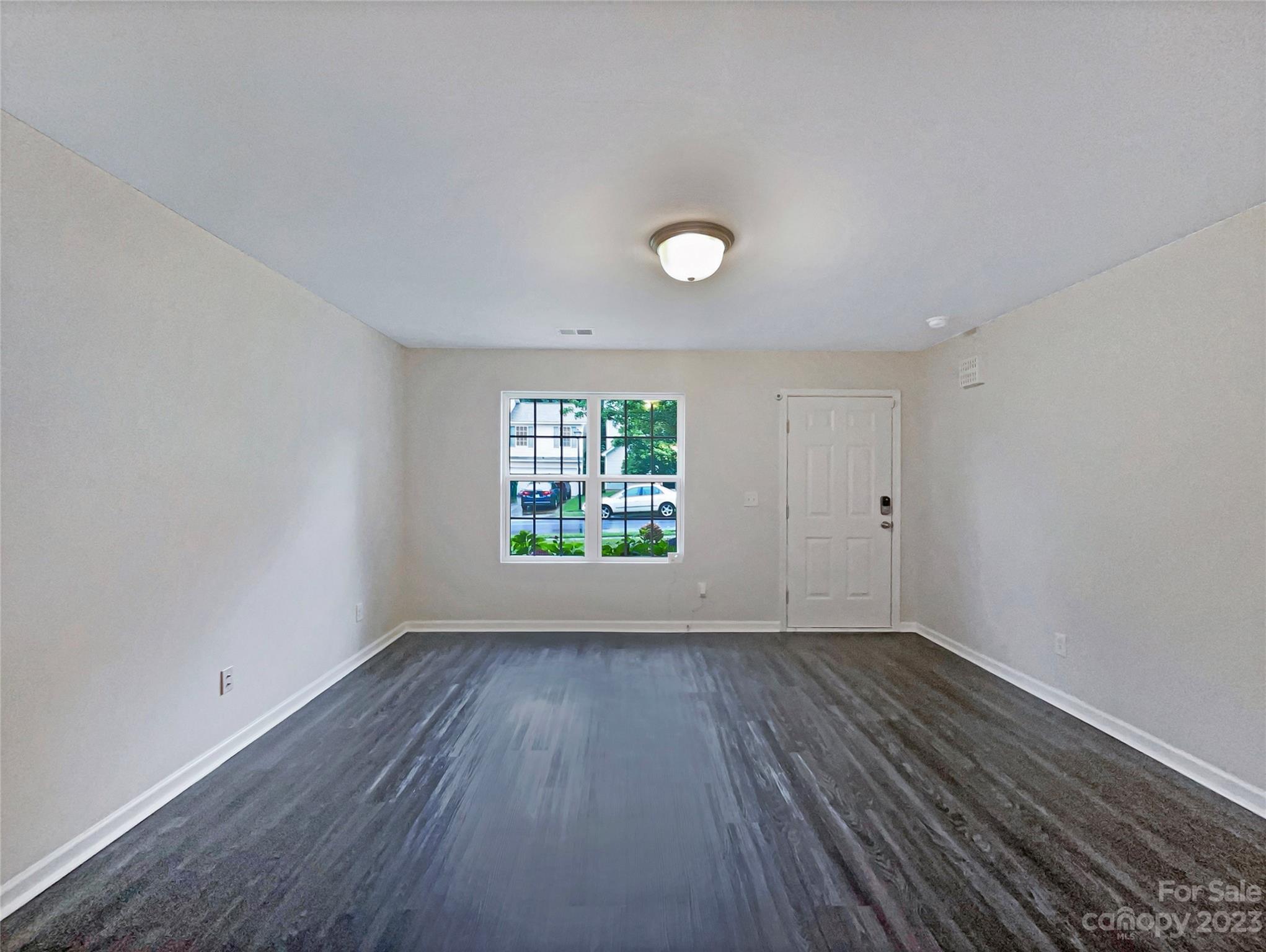 320 Peachtree Road Charlotte, NC 28216 - Photo 3 of 18 an empty room with wooden floor and windows