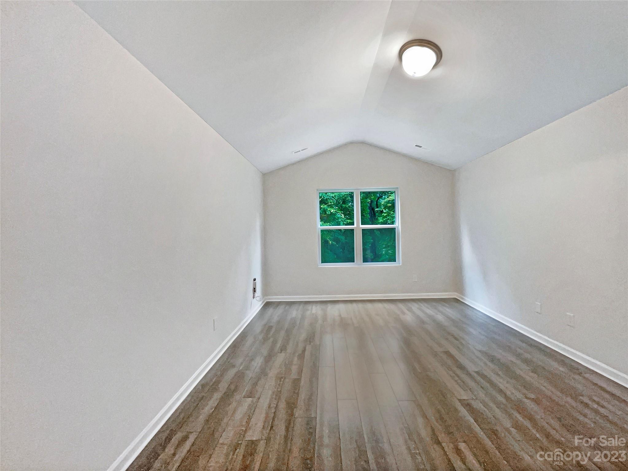 320 Peachtree Road Charlotte, NC 28216 - Photo 5 of 18 an empty room with wooden floor and windows