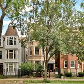 a front view of a residential houses with yard and trees