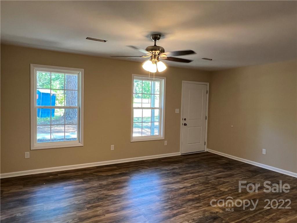 330 Holiday Road Lancaster, SC 29720 - Photo 9 of 12 an empty room with wooden floor chandelier fan and windows