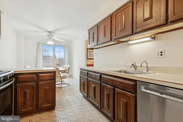 a kitchen with stainless steel appliances granite countertop a sink and dishwasher a stove with wooden cabinets