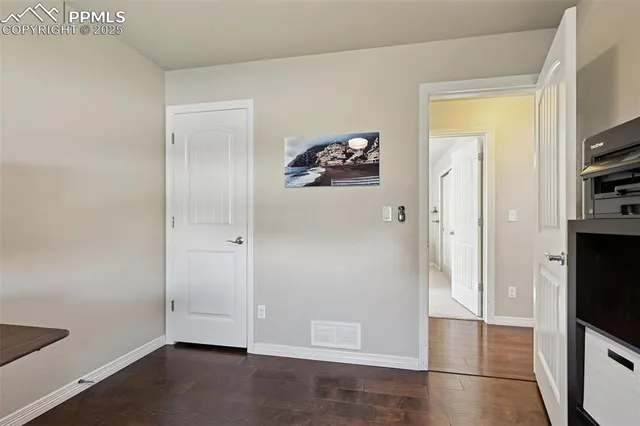 a view of a hallway with wooden floor and a flat screen tv