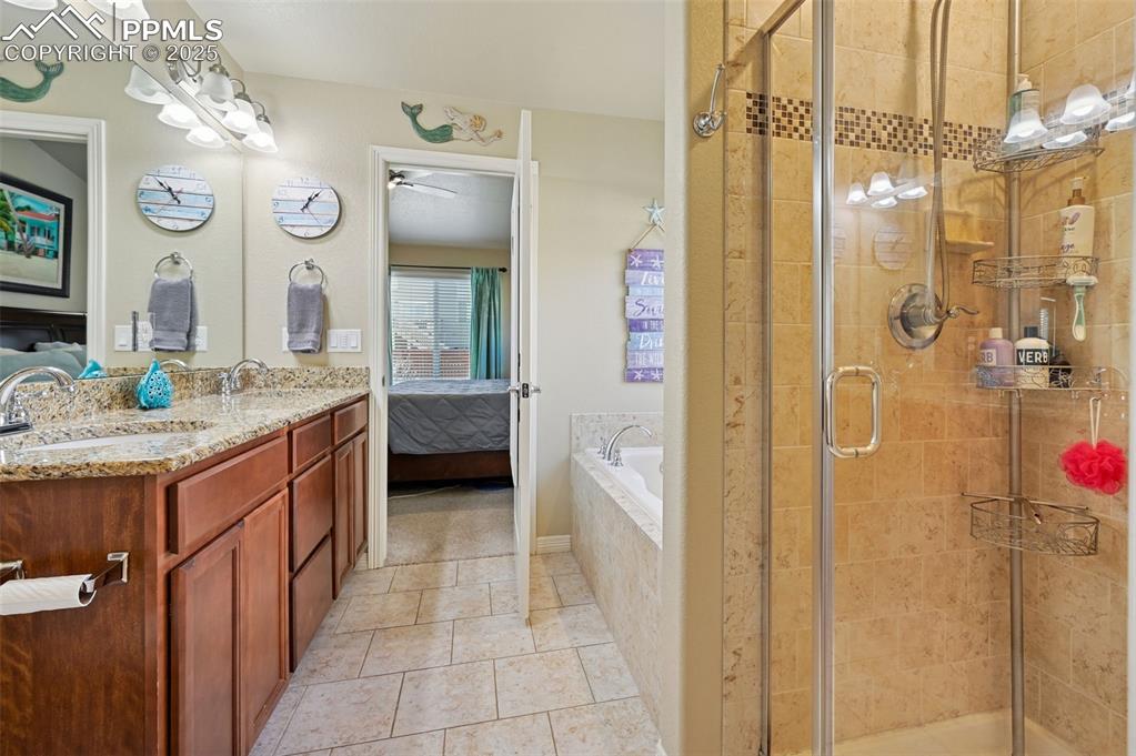 10214 Prairie Ridge Court Peyton, CO 80831 - Photo 22 of 42 a bathroom with a granite countertop sink mirror and shower