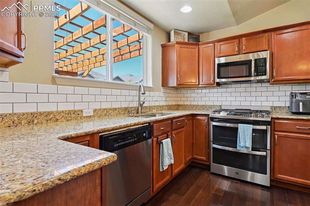 10214 Prairie Ridge Court Peyton, CO 80831 - Photo 9 of 42 a kitchen with stainless steel appliances granite countertop a sink and a microwave