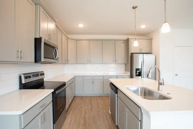 a kitchen that has a sink cabinets counter space and stainless steel appliances