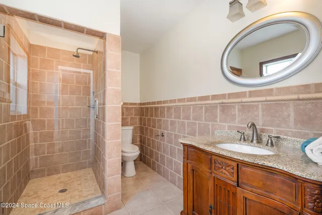 a bathroom with a sink a toilet and a mirror