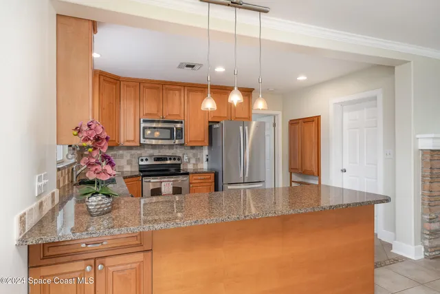 a kitchen with stainless steel appliances granite countertop a sink a stove and a refrigerator