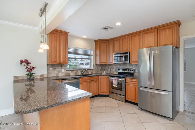 a kitchen with stainless steel appliances granite countertop a refrigerator and a sink