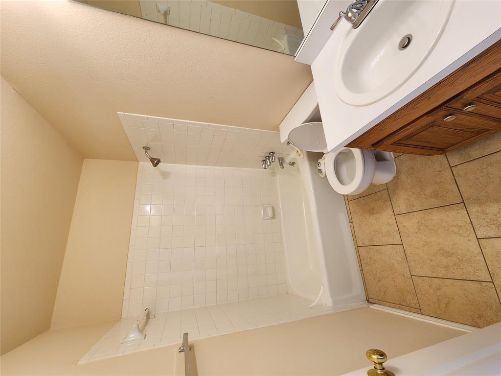8811 Clearbrook Trail Austin, TX 78729 - Photo 5 of 38 lft A - Functional bathroom features a clean white tiled shower and practical vanity.