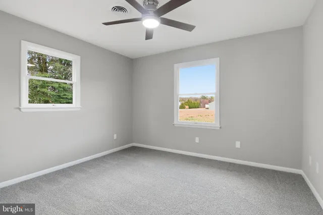 an empty room with a window and a ceiling fan