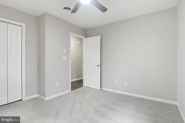 an empty room with chandelier fan