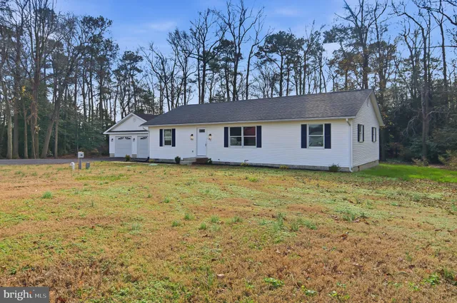 a front view of house with yard and trees around