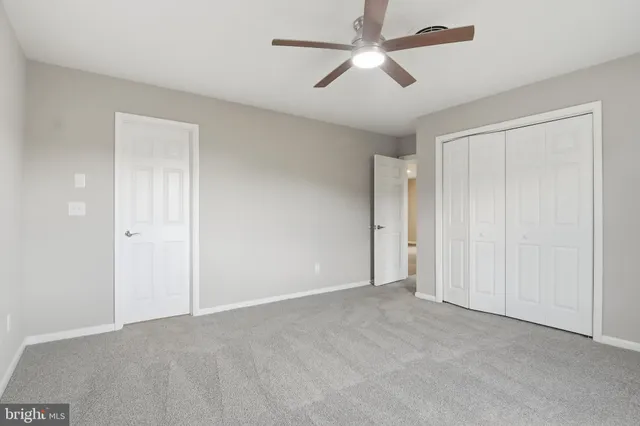 a view of an empty room and a ceiling fan
