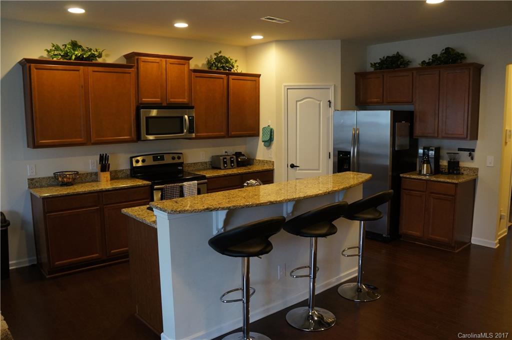 9027 Paddle Oak Road Charlotte, NC 28227 - Photo 2 of 22 a kitchen with stainless steel appliances a sink cabinets and wooden floor