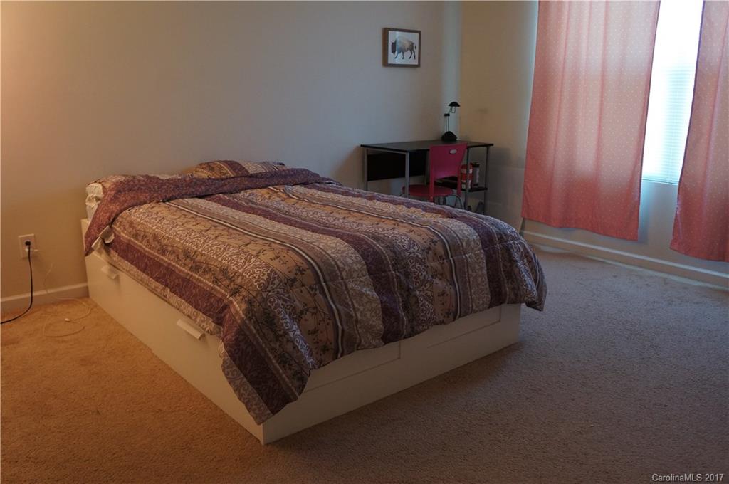 9027 Paddle Oak Road Charlotte, NC 28227 - Photo 13 of 22 a bed sitting in a bedroom next to a window