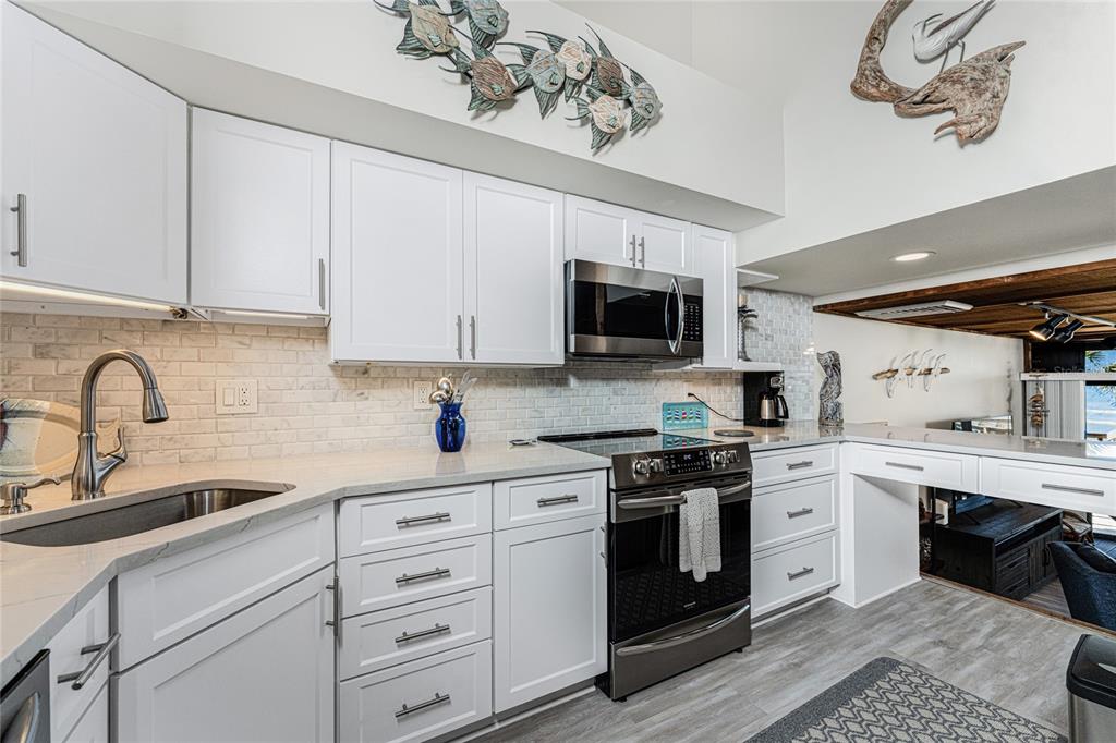 5030 North Beach Road, Unit 3 Englewood, FL 34223 - Photo 22 of 67 a kitchen with cabinets stainless steel appliances and a sink