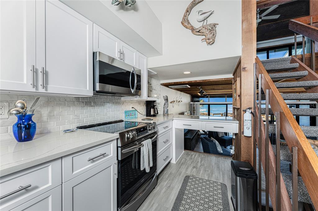 5030 North Beach Road, Unit 3 Englewood, FL 34223 - Photo 23 of 67 a kitchen with stainless steel appliances granite countertop a stove and a microwave