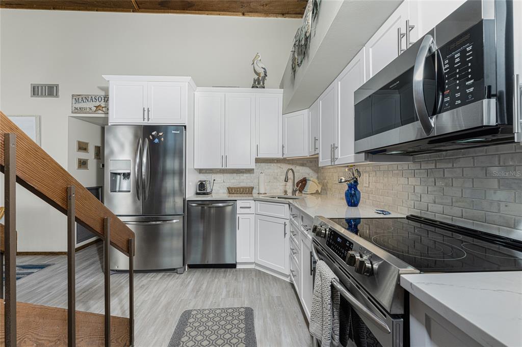 5030 North Beach Road, Unit 3 Englewood, FL 34223 - Photo 26 of 67 a kitchen with stainless steel appliances granite countertop a refrigerator sink and stove