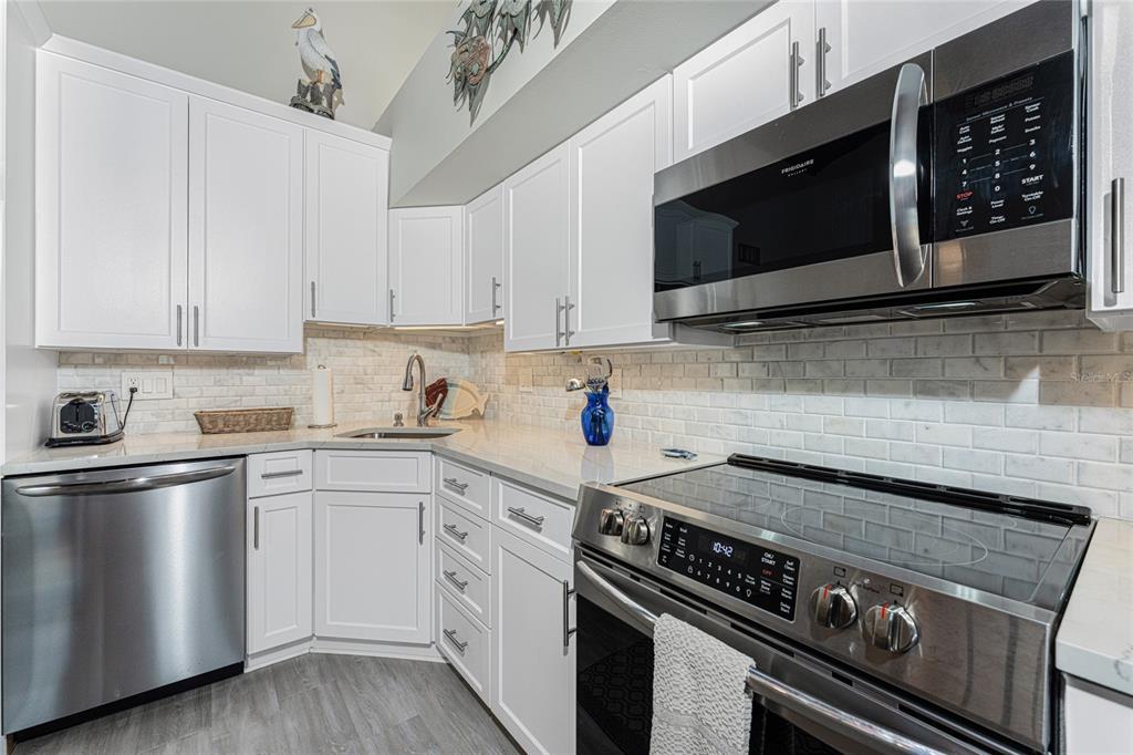 5030 North Beach Road, Unit 3 Englewood, FL 34223 - Photo 27 of 67 a kitchen with stainless steel appliances a sink a stove and cabinets
