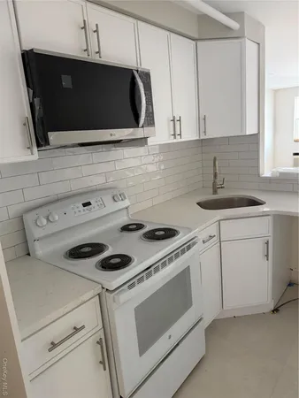 a kitchen with white cabinets and white appliances